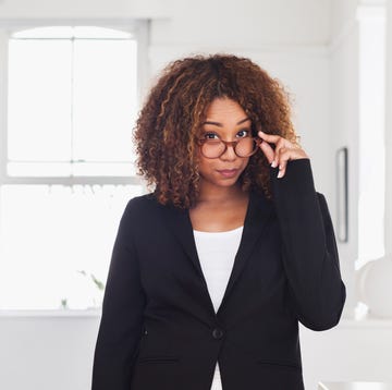 mixed race woman peering over eyeglasses in gallery