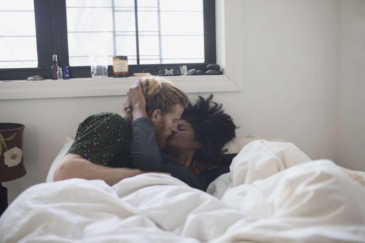 A young couple kissing in bed