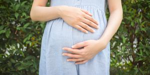 Midsection Of Pregnant Woman Standing At Park
