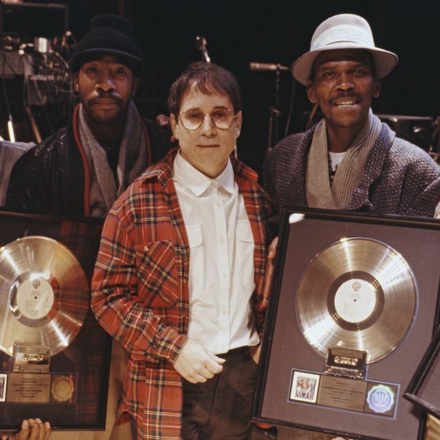 Paul Simon with four musicians, all holding gold discs of Paul Simon's album Graceland, on which they contributed, London, 1987