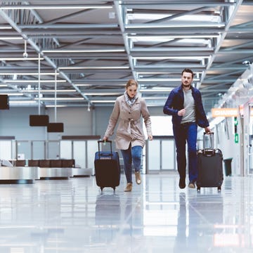 Young couple running marketing towards boarding gate in airport