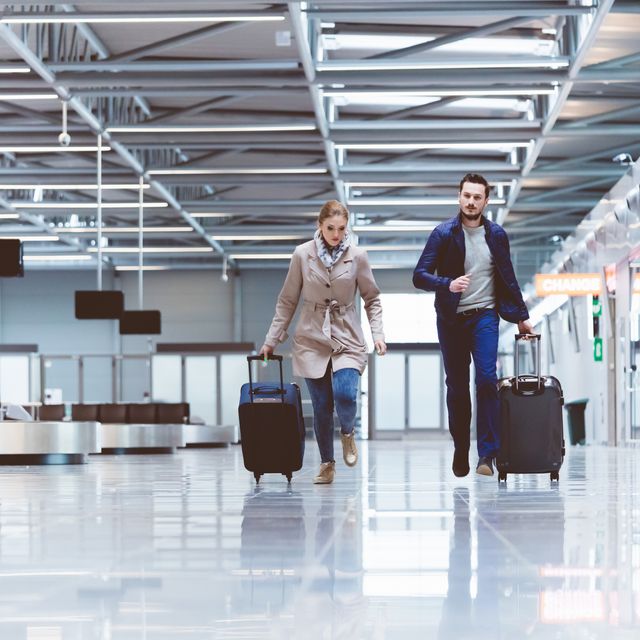 Young couple running towards boarding gate in airport