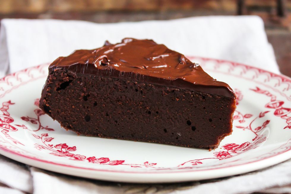 piece of chocolate brownie cake with dark chocolate icing on a dessert plate, selective focus