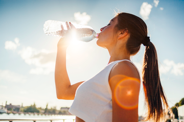 woman drinking from water bottle