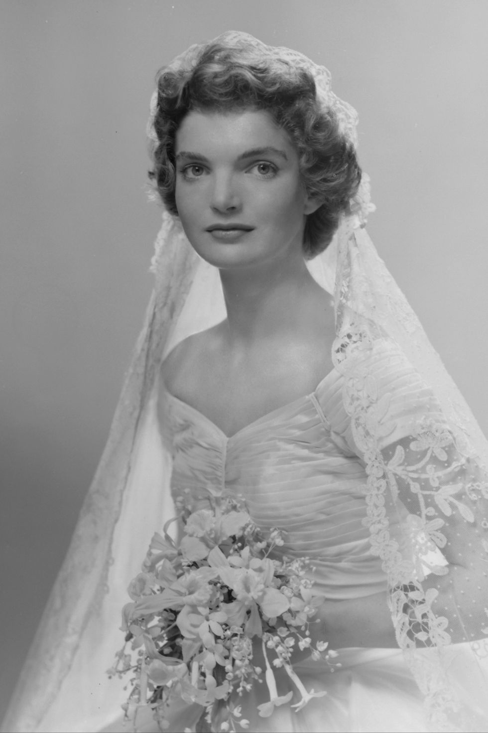 bridal portrait of jacqueline lee bouvier 1929   1994 shows her in an anne lowe designed wedding dress, a bouquet of flowers in her hands, new york, new york, 1953 photo by bachrachgetty images