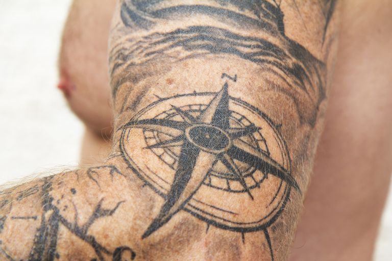 arm tattooed with compass rose