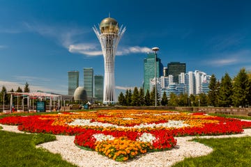 the bayterek tower is a symbol of kazakhstan the central boulevard, with flower beds leading up to bayterek tower,