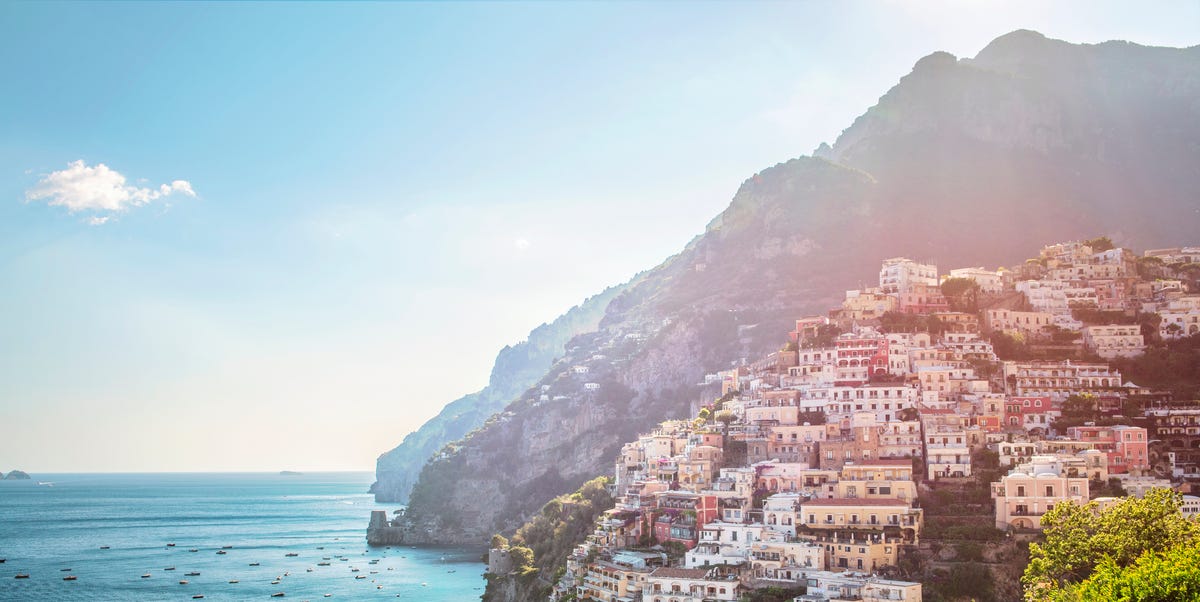 positanos colourful villas stacked vertically up the side of the cliff with leisure and fishing boats on the ocean