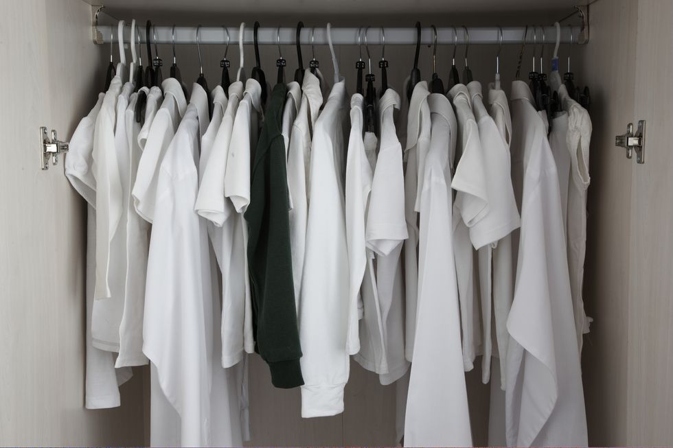 white clothes in cupboard, one green
