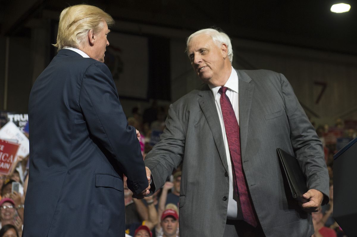 us president donald trump shakes hands with west virginia governor jim justice, who announced during the rally he would switch parties from democrat to republican, during a make america great again rally at big sandy superstore arena in huntington, west virginia, august 3, 2017  afp photo  saul loeb        photo credit should read saul loebafp via getty images