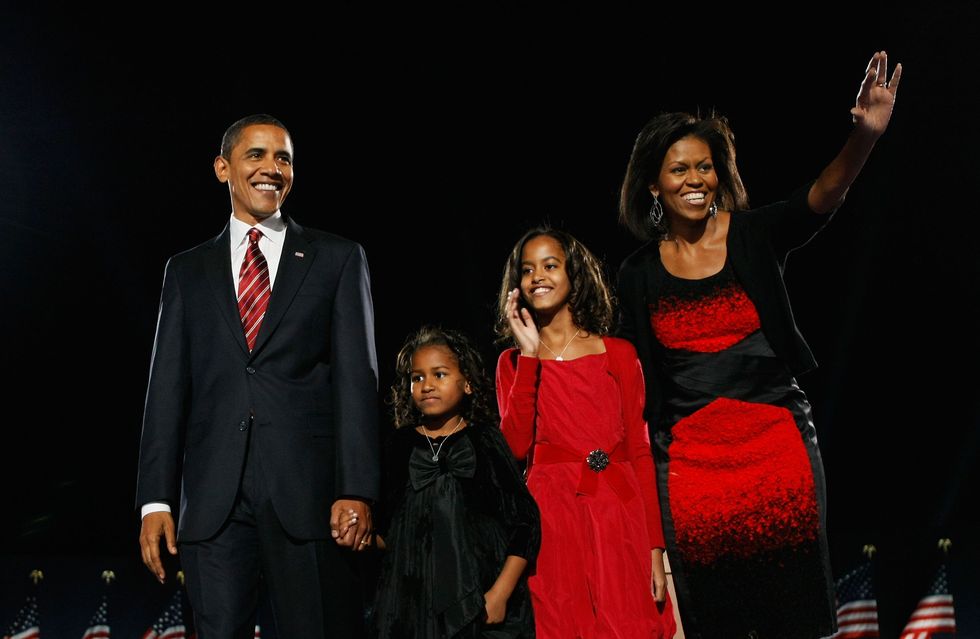 chicago   november 04  us president elect barack obama stands on stage along with his wife michelle and daughters malia red dress and sasha  black dress during an election night gathering in grant park on november 4, 2008 in chicago, illinois obama defeated republican nominee sen john mccain r az by a wide margin in the election to become the first african american us president elect  photo by joe raedlegetty images