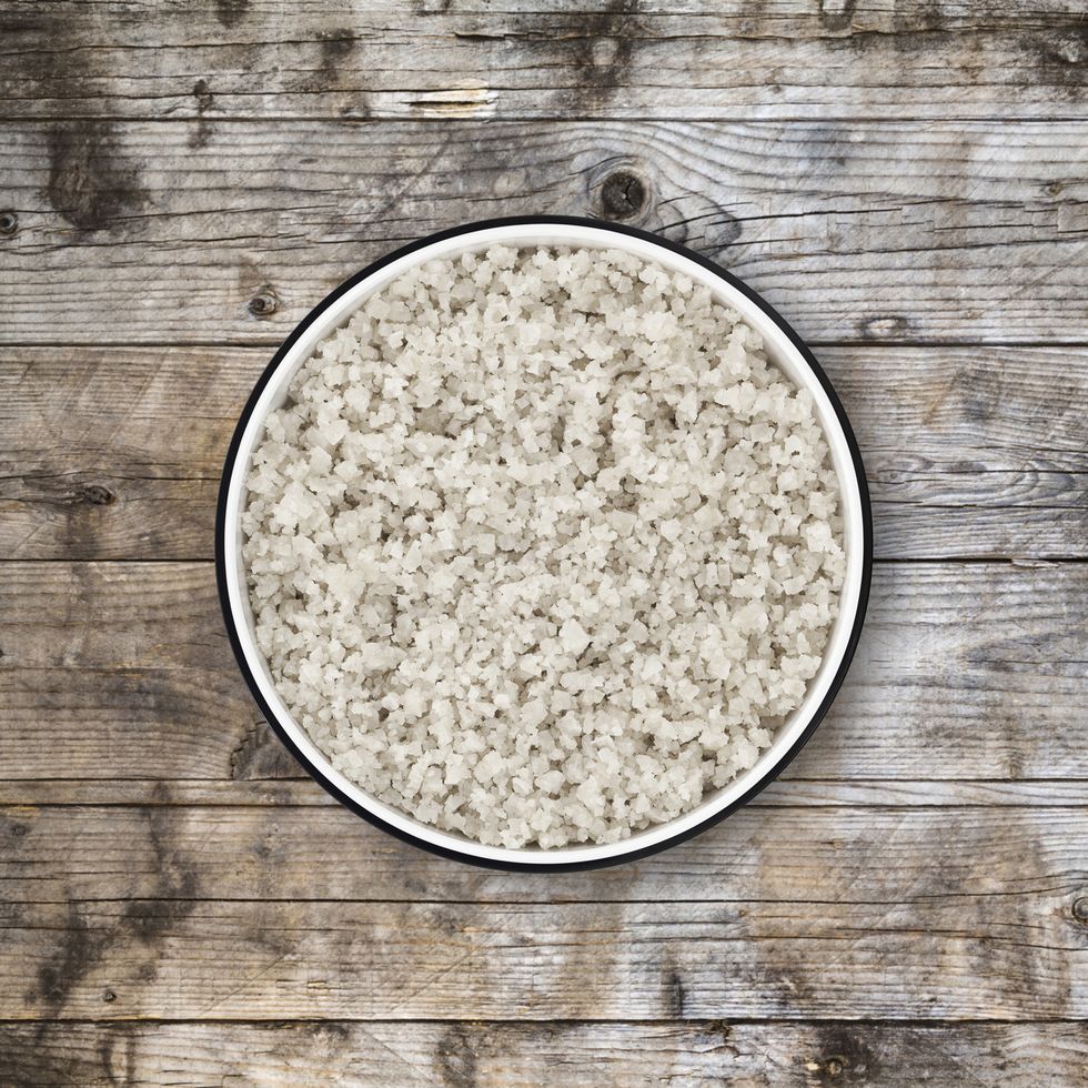 Sea salt bowl on wood background from directly above