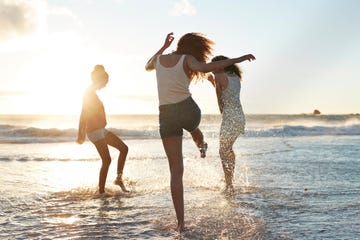 young women hanging out at the beach, at sunset