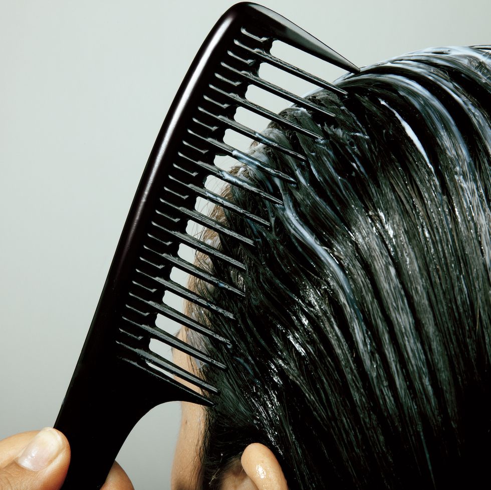 closeup of woman combing wet dark hair