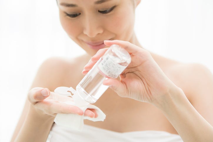 a woman doing skin care with cosmetic lotion