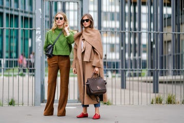 paris, france september 28 a guest l wears a green top, brown flare pants  a guest r wears a camel coat, red shoes outside carven, during paris fashion week womenswear springsummer 2018, on september 28, 2017 in paris, france photo by edward berthelotgetty images