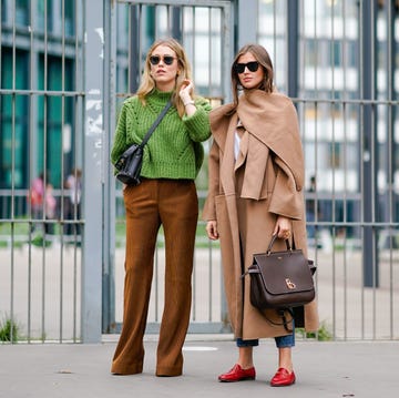 Street Style : Paris Fashion Week Womenswear Spring/Summer 2018 : Day Three paris, france september 28 a guest l wears a green top, brown flare pants a guest r wears a camel coat, red shoes outside carven, during paris fashion week womenswear springsummer 2018, on september 28, 2017 in paris, france photo by edward berthelotgetty images