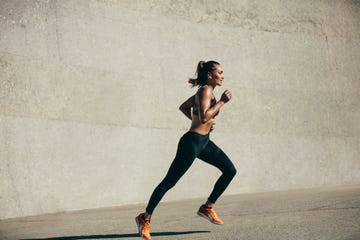 healthy young woman running in morning fitness model exercising in morning outdoors full length side view shot