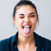 woman sticking her tongue out with one eye closed