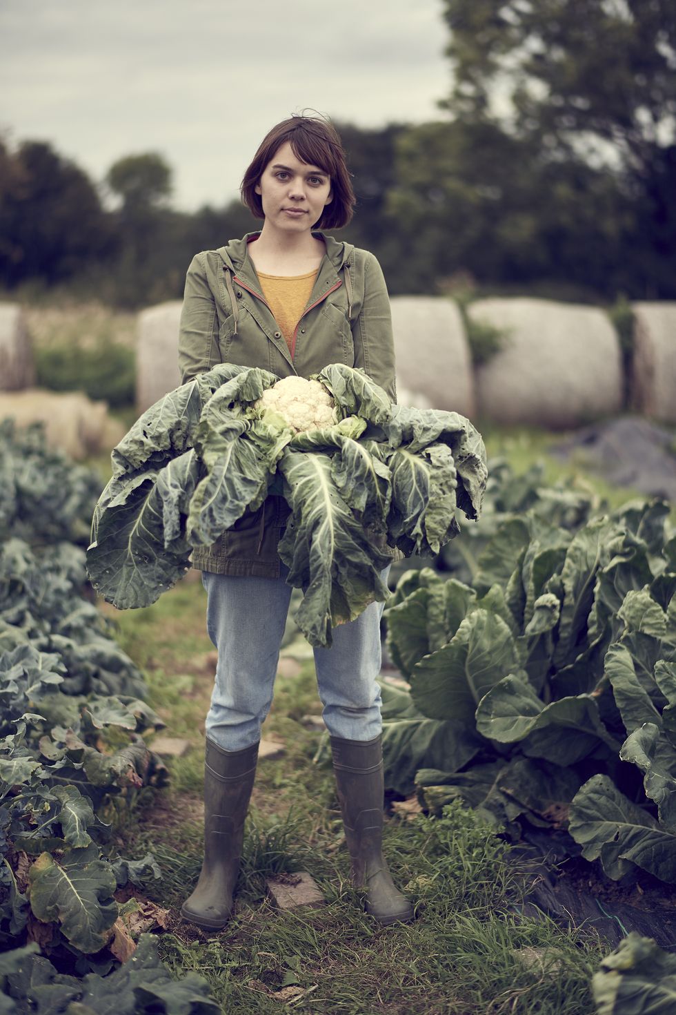 Portrait of young female community farmer holding cauliflower