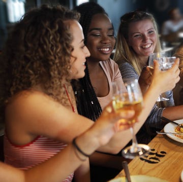 women toasting with glasses at a dinner table