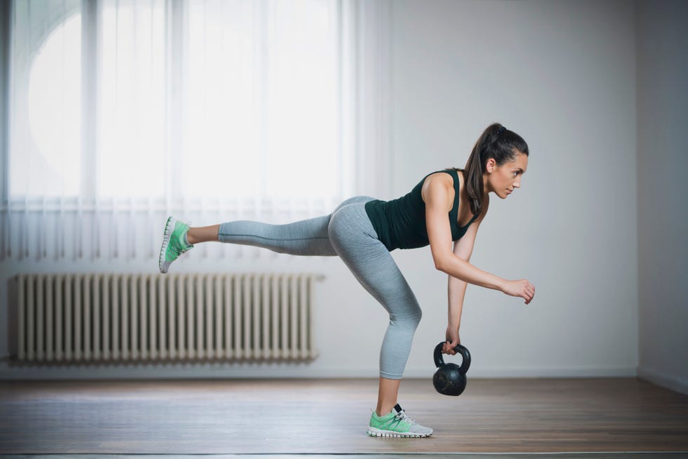 young woman doing single leg kettlebell deadlift