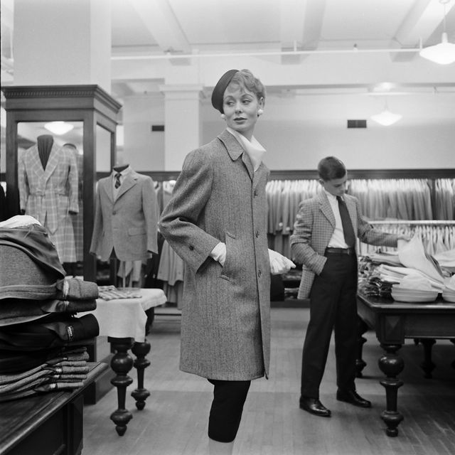 subject woman wearing long coat with hat and gloves while shopping in a brooks brothers department store while young boy shops through a pile of button down dress shirts new york, ny march 1954nphoto by nina leenthe life picture collection via getty images