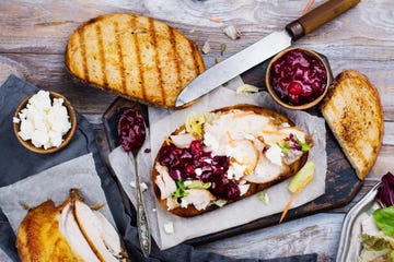 homemade leftover thanksgiving day sandwich with turkey, cranberry sauce, feta cheese and vegetables top view