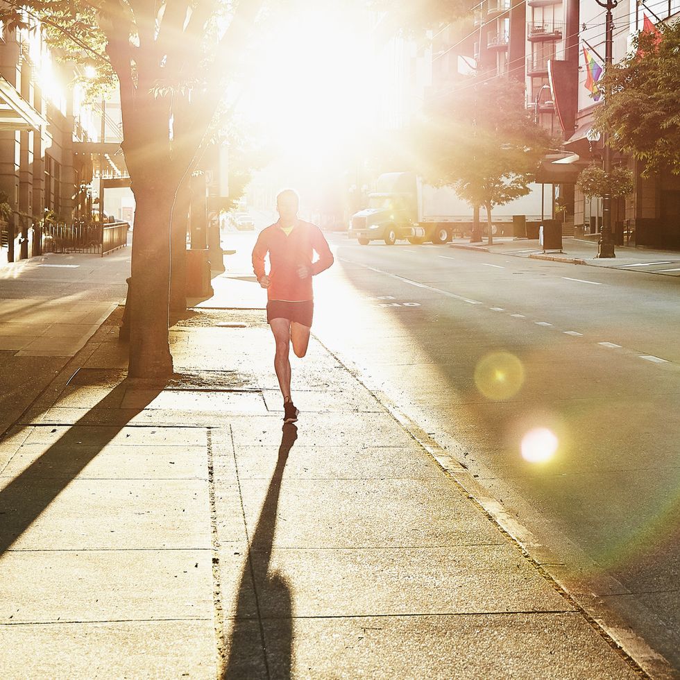 Man running on empty city street during early morning workout