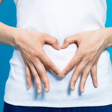 young woman who makes a heart shape by hands on her stomach. young woman who makes a heart shape by hands on her stomach