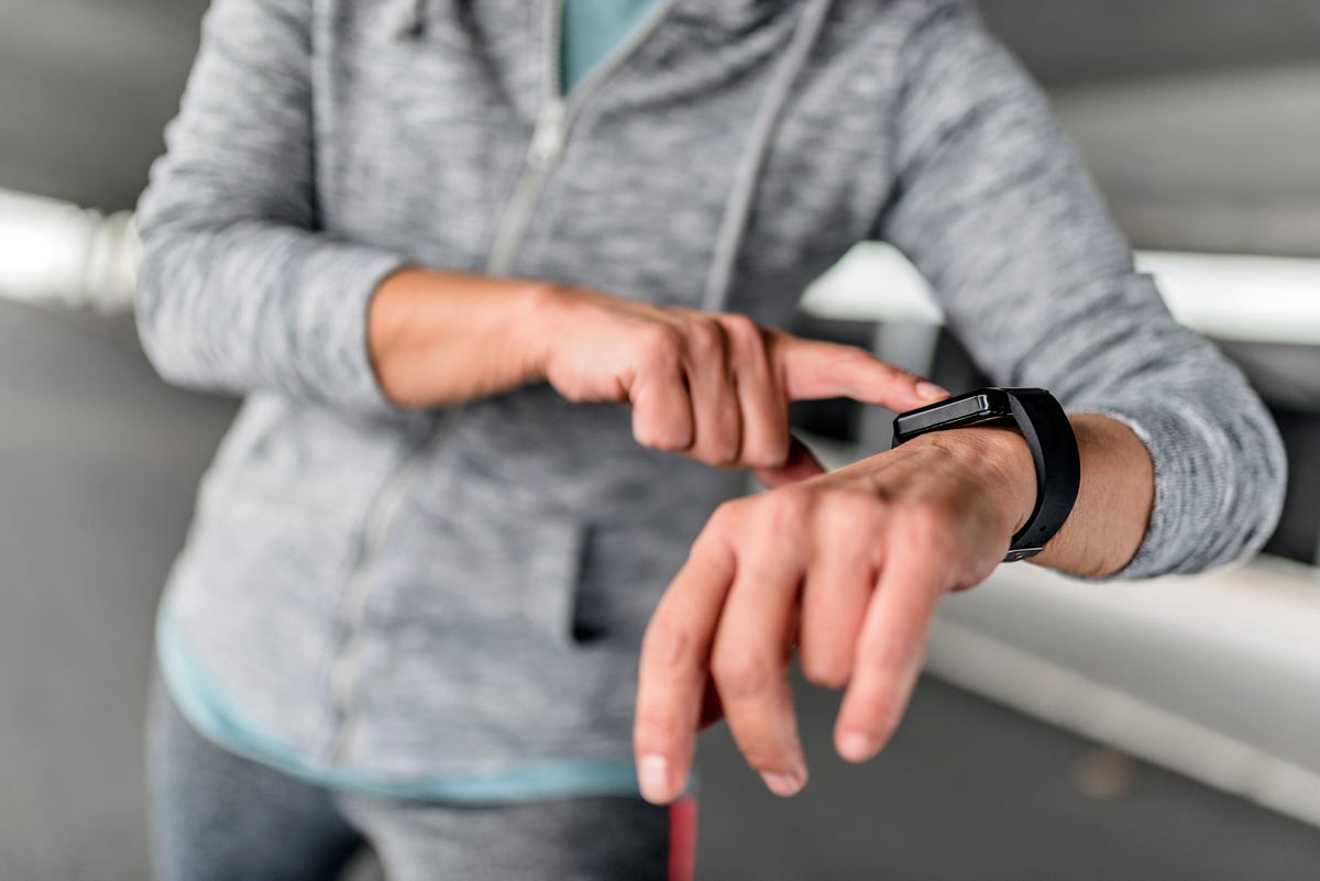 closeup of smart watch on female hand girl dressed in gray sweatshirt  and using digital gadget young woman presses a finger on the side button smartwatchstudent using smart watch checking messages  maure female running in the city during autumn day senior sportswoman using smartwatch to track her workout performance fitness female monitoring her progress