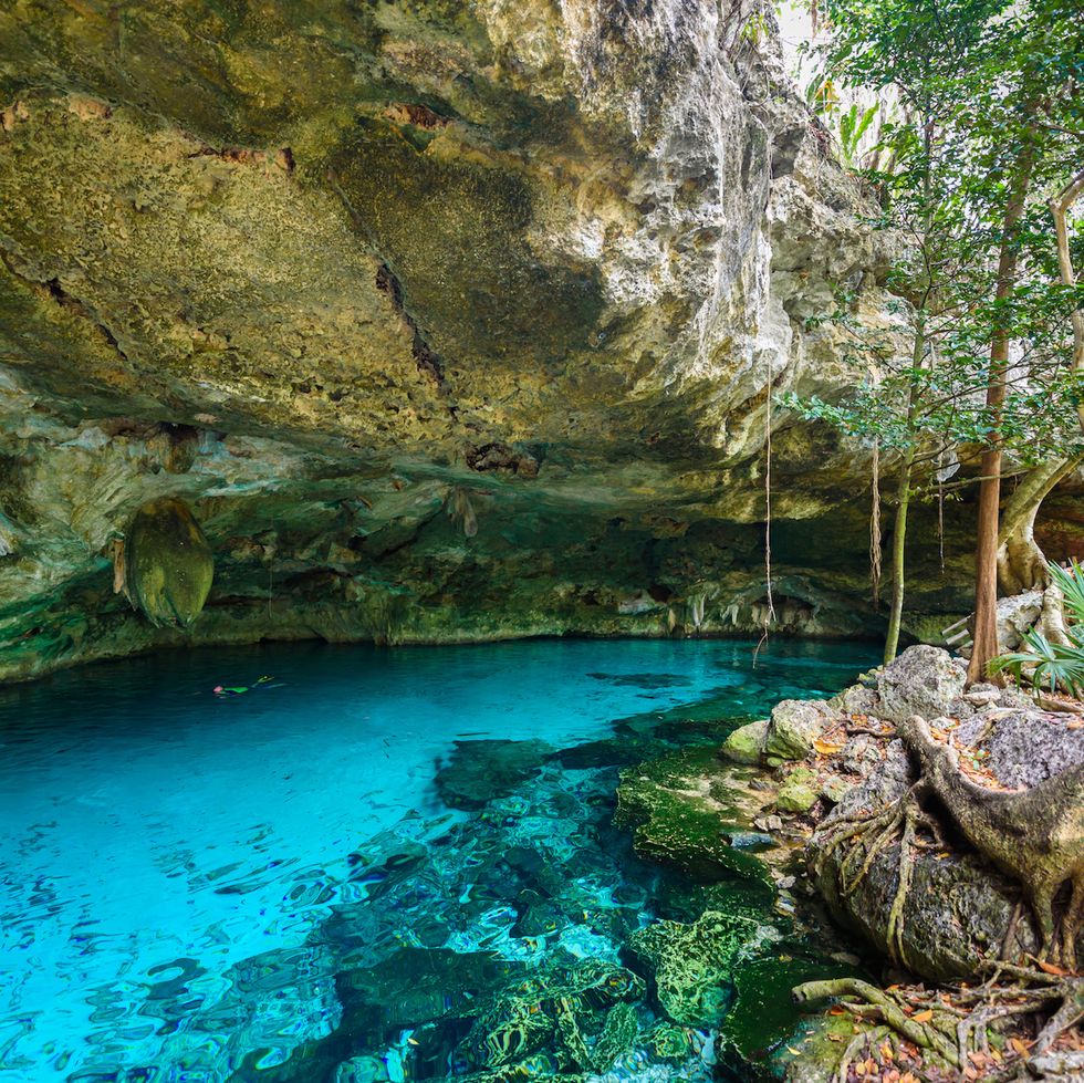 cenote dos ojos in quintana roo, mexico people swimming and snorkeling in clear blue water this cenote is located close to tulum in yucatan peninsula, mexico