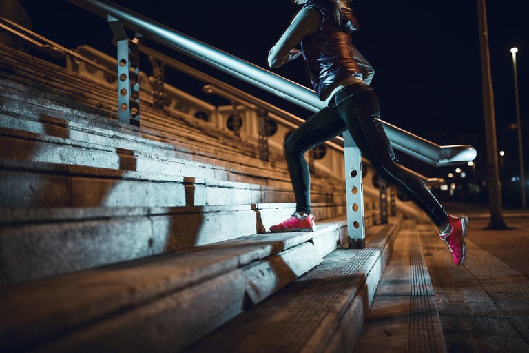 Young woman running at night in a urban city area