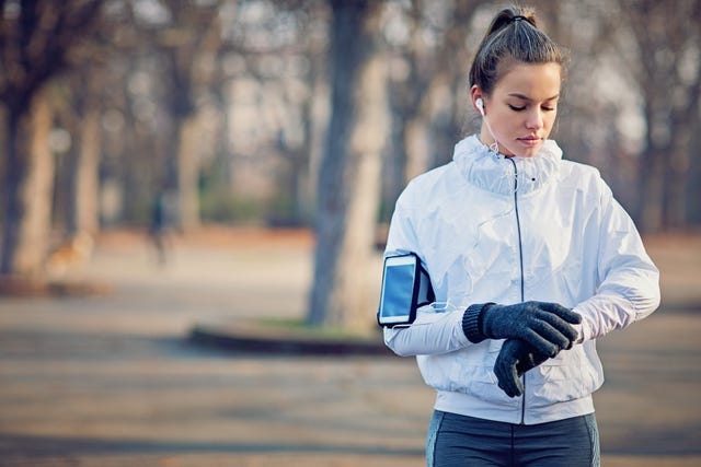 Runner girl is resting and checking her smart watch