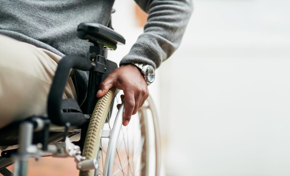 cropped shot of an unrecognizable senior man sitting in his wheelchair at home