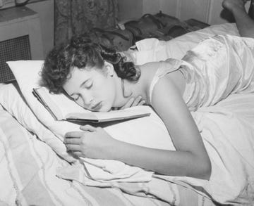 a young woman asleep with her face resting on the book she has been reading, circa 1955 photo by hulton archivegetty images