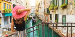 Elegant woman enjoys the view to a canal in Venice