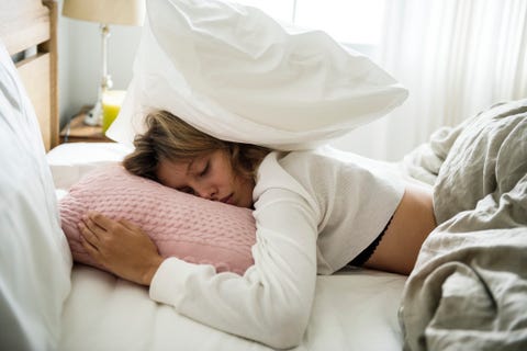 A Caucasian woman sleeping on her bed