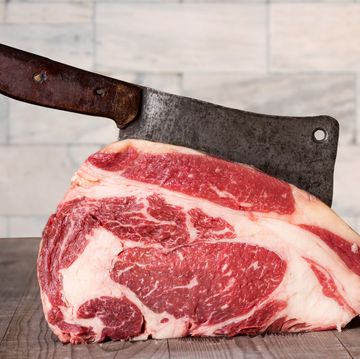 raw prime rib beef with meat cleaver