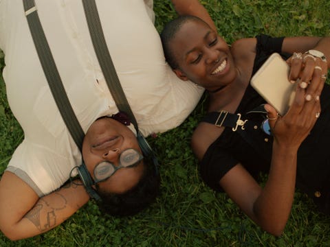 two friends hanging out in a park in london a non binary queer person and a bisexual woman