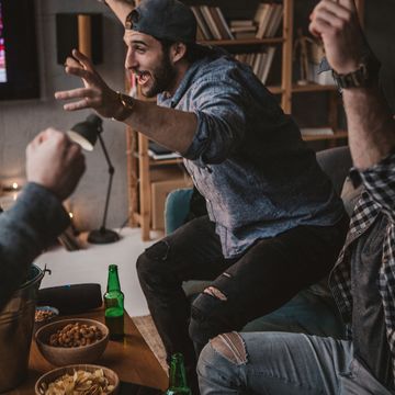 group of friends watching basketball game on tv at home