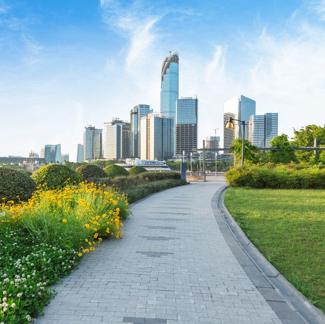 park pedestrian walkway toward modern skyscrapers,suzhou city,china