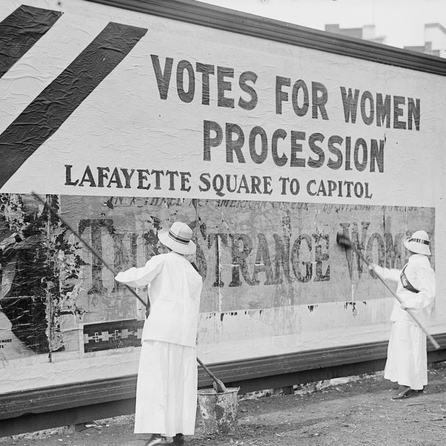Suffragettes uses Long Brushes to Post a Billboard announcing a "Votes" For Women" Parade
