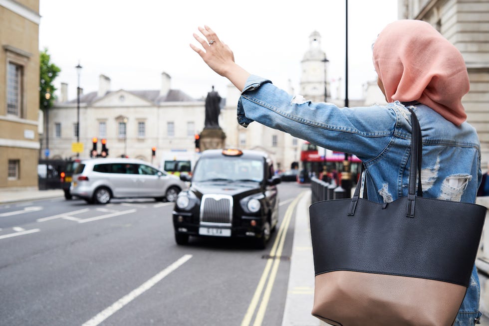 london, uk, england, young student muslim girl calling a taxi in the city, muslim university student