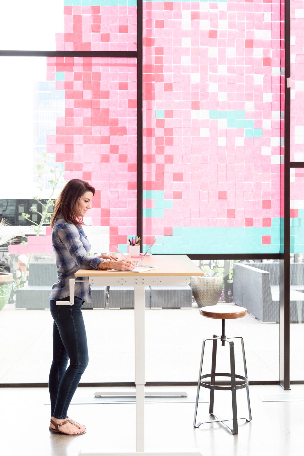 Caucasian woman using laptop at standing workstation