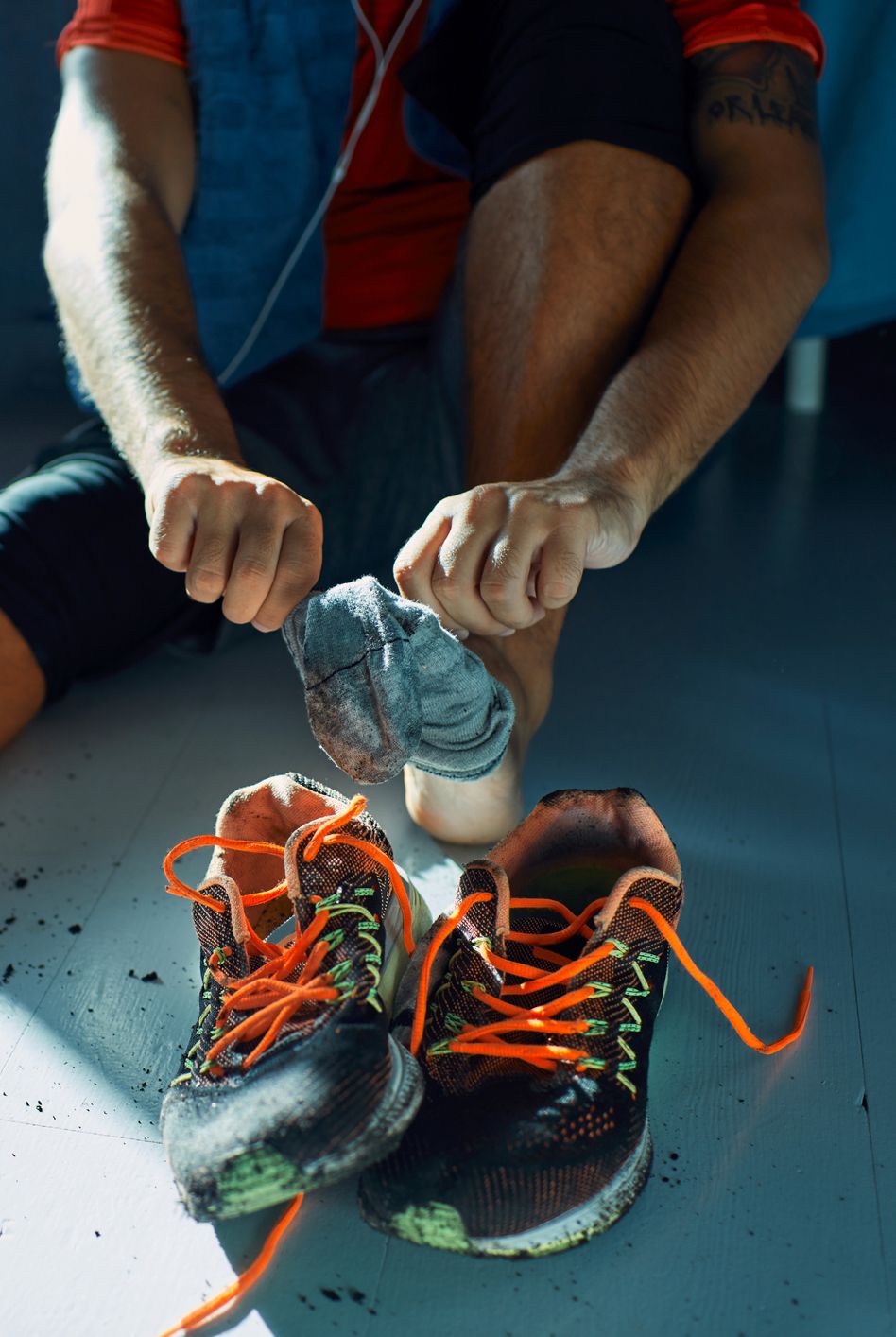 close up of a man getting his dirty shoes off after a workout
