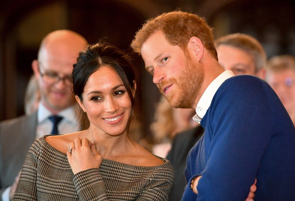cardiff, wales   january 18  prince harry whispers to meghan markle as they watch a dance performance by jukebox collective in the banqueting hall during a visit to cardiff castle on january 18, 2018 in cardiff, wales photo by ben birchall   wpa pool  getty images