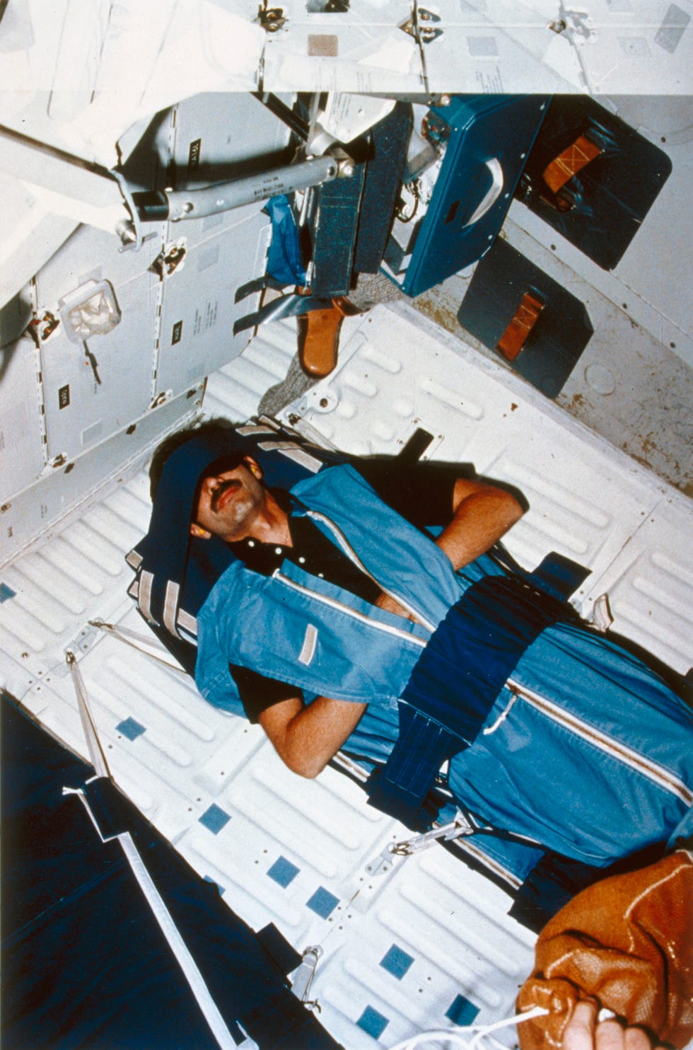 Shuttle astronaut in sleep restraint, 1980s.