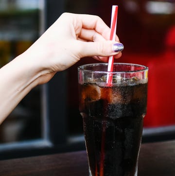 Cropped Hand Of Woman Holding Drink At Cafe