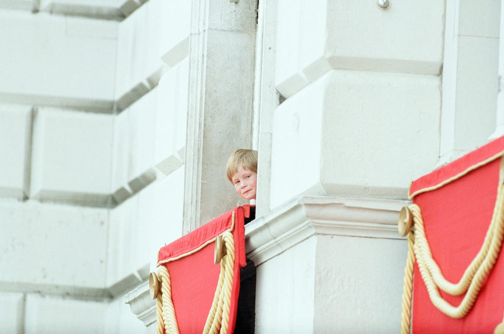 prince harry looking down from buckingham palace window at proceedings in courtyard